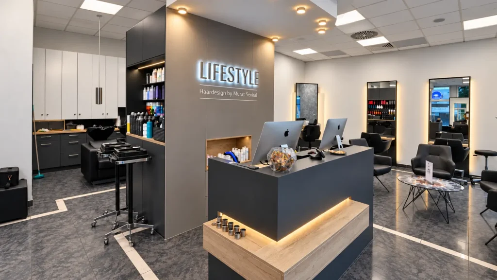 Empfangsbereich des Salons Lifestyle Haardesign mit beleuchtetem Tresen und Schriftzug